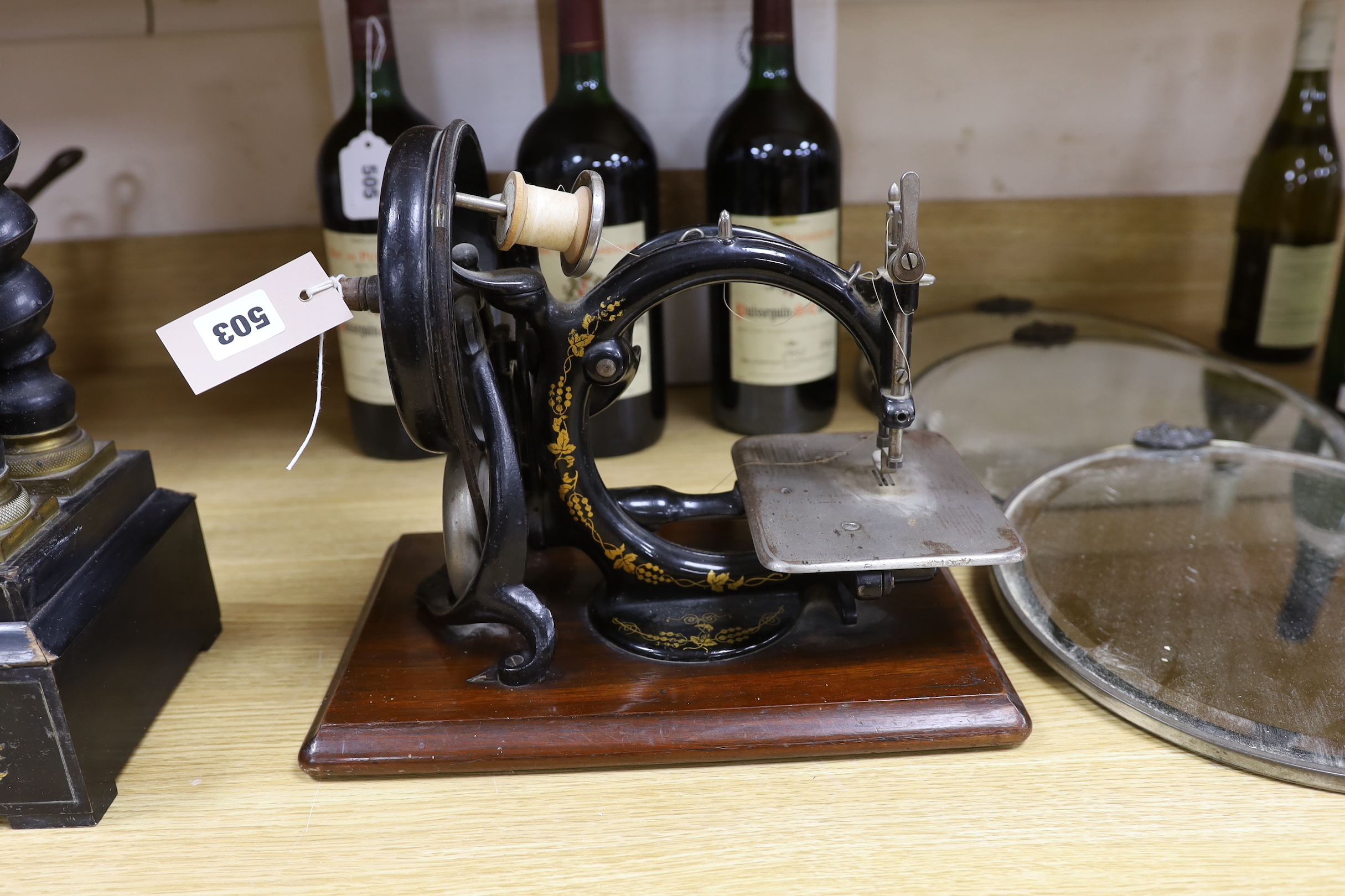 A Willcox & Gibbs sewing machine, and a set of three circular bevelled wall mirrors, 31cm